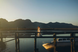 Wedding Photo walking on a wooden bridge with a mini boat